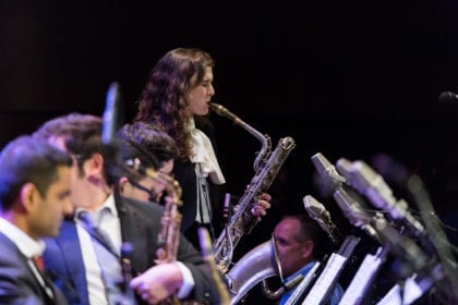 A group of students in the MSM Jazz Orchestra of the Manhattan School of Music in performance, with a saxophonist giving a solo