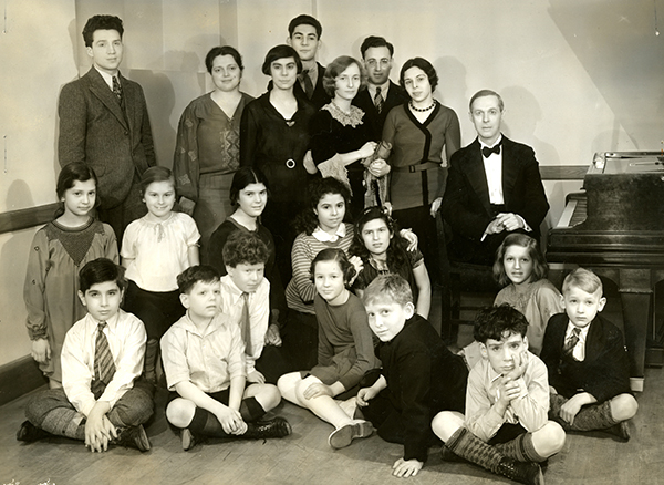 room full of children and adults, man at piano