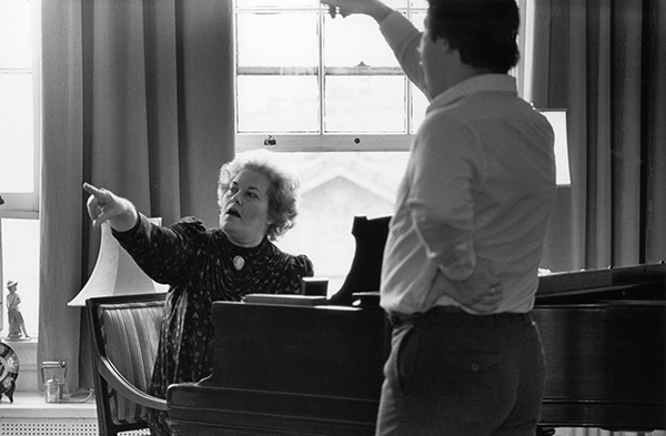 woman at piano teaching student to sing