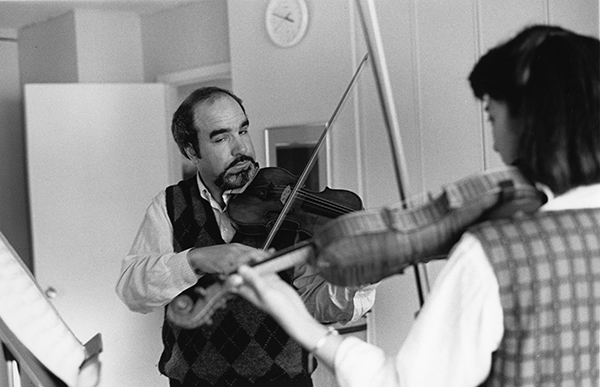 man with violin teaching a student