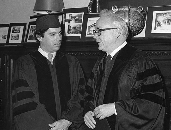 two men wearing graduation gowns