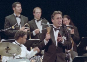 man in tux playing percussion in front of musicians