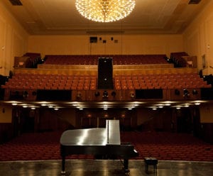 large concert hall with grand piano on stage