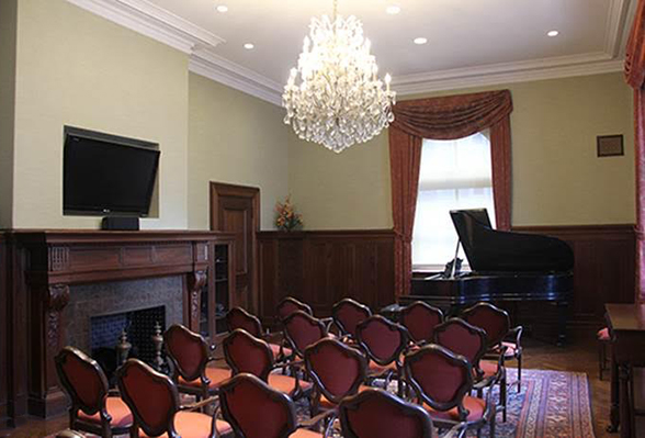 rich room with chandelier, fireplace, and grand piano