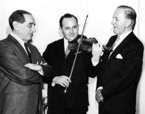three men in suits, one playing the violin