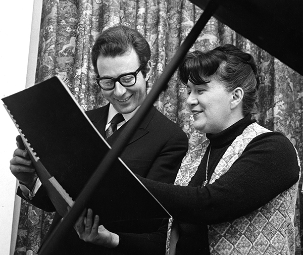 man and woman study an orchestral score